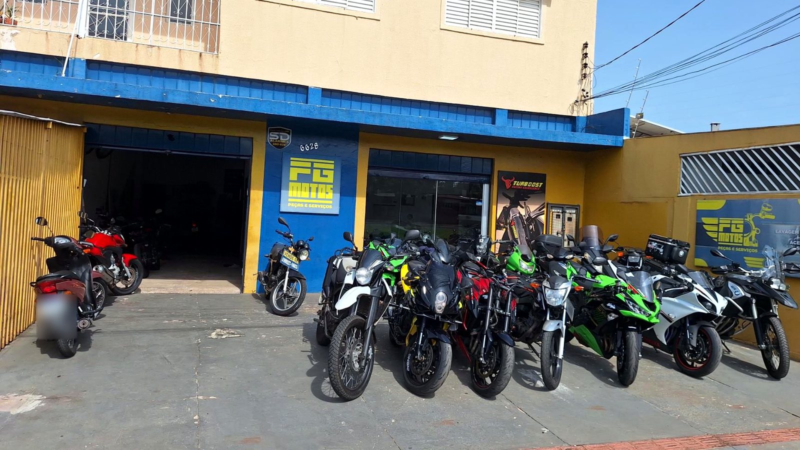 Fachada da Oficina FG Motos na Av. Fábio Zahran, 6628, Vila Carvalho, com motos no pátio.
